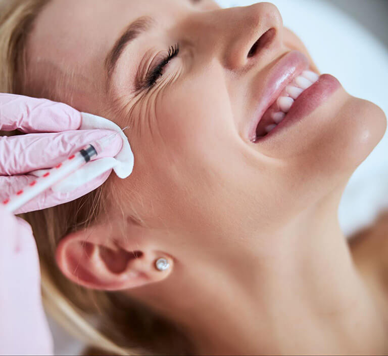Woman receiving an injectable wrinkle treatment for her crow's feet.