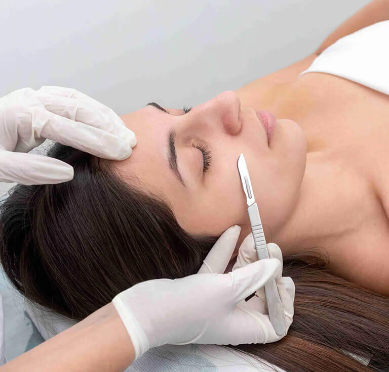 Young woman receives dermaplaning treatment.