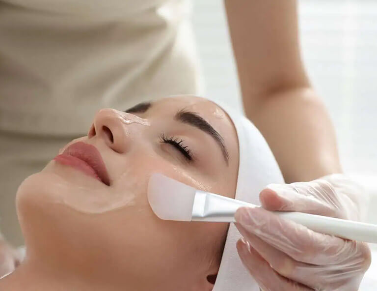 Young woman during face peeling procedure in salon.